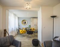 a living room with a dining room table with yellow chairs at Le Flamboyant - Confort &amp; Rareté - Premium in Saint-André-les-Vergers