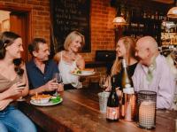 un grupo de personas sentadas alrededor de una mesa en un bar en The Lancefield Lodge, en Lance Field