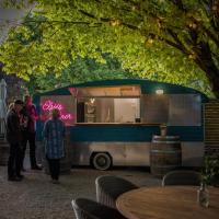 un grupo de personas de pie en frente de un camión de comida en The Lancefield Lodge, en Lance Field