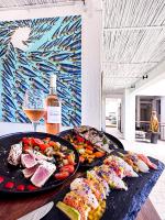 Una mesa con dos platos de comida y una botella de vino. en Cosy Guest House Sous le Badamier, en Grand Baie