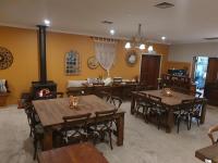 Un comedor con mesas de madera y una estufa de leña. en The Lancefield Lodge, en Lance Field