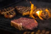 Un grupo de carnes y hamburguesas en una parrilla. en The Lancefield Lodge, en Lance Field