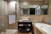 a bathroom with a sink and a tub and a mirror at The Tango Hotel Taipei Nanshi in Taipei