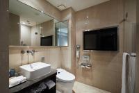 a bathroom with a sink and a toilet and a tv at The Tango Hotel Taipei Nanshi in Taipei