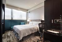 a bedroom with a bed and a desk and a piano at The Tango Hotel Taipei Nanshi in Taipei