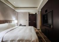 a bedroom with a large bed and a flat screen tv at The Tango Hotel Taipei Nanshi in Taipei