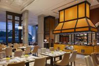 Un restaurante con mesas y sillas y un bar. en The Ritz-Carlton, Pune, en Pune