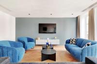 a living room with blue couches and a tv at Spacious &amp; Modern Home in Central Paris - 3BR8P - A40 in Paris