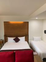 a bedroom with two beds with white and red pillows at 開心居-正市中心電梯民宿-步行東大夜市5分鐘 in Hualien City