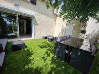 a patio with a table and chairs on the grass at Maison Belissima in Marseille