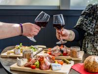 duas pessoas segurando taças de vinho ao lado de uma mesa de comida em Première Classe Melun Senart em Vert-Saint-Denis