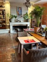een woonkamer met een open haard en een tafel en stoelen bij Hostellerie Les Hauts De Sainte Maure in Sainte-Maure-de-Touraine