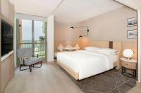 a bedroom with a white bed and a balcony at Sheraton Abu Dhabi Hotel & Resort in Abu Dhabi
