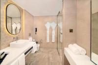 a bathroom with a sink and a shower and a mirror at Sheraton Abu Dhabi Hotel & Resort in Abu Dhabi