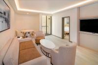 a living room with a television and a table and chairs at Sheraton Abu Dhabi Hotel & Resort in Abu Dhabi
