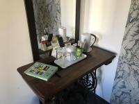 a table with a mirror and a tray with drinks on it at The Originals Boutique, Hôtel d&#39;Angleterre, Le Havre, centre, plage in Le Havre