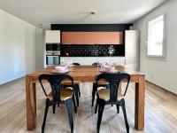 a kitchen with a wooden table and chairs with wine glasses at Le Saint-Jalmes P2 + Parking in Nîmes