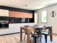 a kitchen with a wooden table and black and white cabinets at Le Saint-Jalmes P2 + Parking in Nîmes