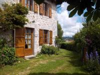 a stone house with wooden doors and a yard at Gîte Sansac-Veinazès, 3 pièces, 4 personnes - FR-1-742-114 