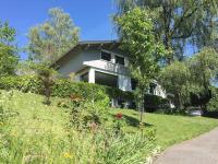 a white house sitting on top of a lush green yard at Appartement indépendant 30 m² à 500m du lac, 2 vélos et parking fournis in Sévrier