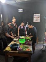un grupo de personas de pie alrededor de una mesa preparando comida en Ella Rock Heaven, en Ella