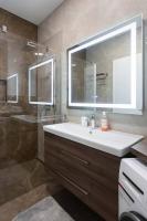 a bathroom with a sink and a mirror and a shower at Lux oasis with private parking in Zagreb