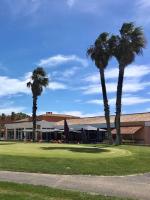 two palm trees in front of a building at Palmyra Golf Hotel & Spa in Cap d'Agde