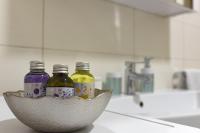 three bottles of liquid in a bowl on a kitchen counter at Apartment Ivana in Roč