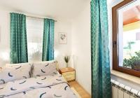 a bedroom with blue curtains and a bed with a window at Apartment Ivana in Roč