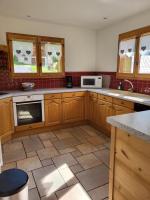 a kitchen with wooden cabinets and a microwave at La petite Anfiane in Le Grand-Bornand