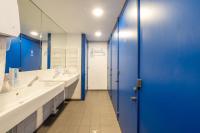 a bathroom with two sinks and a blue door at UCPA SPORT STATION HOSTEL PARIS in Paris