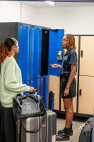 two women standing in a locker room with luggage at UCPA SPORT STATION HOSTEL PARIS in Paris