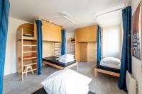 a dorm room with two beds and blue curtains at UCPA SPORT STATION HOSTEL PARIS in Paris