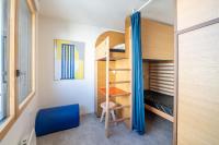 a small bedroom with a bunk bed with a blue curtain at UCPA SPORT STATION HOSTEL PARIS in Paris