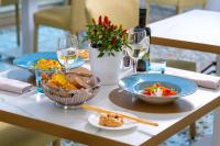 een tafel met borden met eten en glazen wijn bij Hermitage Resort & Thermal Spa in Ischia
