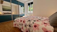 a bedroom with a bed with a floral bedspread at L&#39;Escapade de Pierrefonds par Your Sweet Loc in Pierrefonds