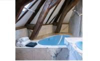 a bathroom with a blue tub in a attic at Suite Toussaint - Calme &amp; Authentique in Angers