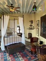 1 dormitorio con 1 cama con ventilador de techo y chimenea en Hacienda Las Amantes, en San Miguel de Allende
