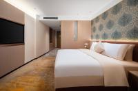 Guangzhou Wogo Yuanbao Hotel-Zhujiang New Town-Free Canton Fair Shuttle Bus & Overseas Buyer Registration Servicesにあるベッド