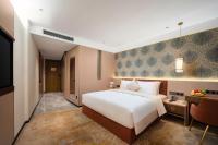 Guangzhou Wogo Yuanbao Hotel-Zhujiang New Town-Free Canton Fair Shuttle Bus & Overseas Buyer Registration Servicesにあるベッド