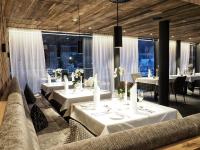 ein Restaurant mit weißen Tischen und Stühlen und Fenstern in der Unterkunft Wellness & Naturresort Reischlhof in Wegscheid