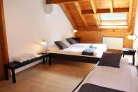 Dos camas en una habitación con techos de madera. en La Pierre à Catillon, en Moleson