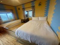 a bedroom with a large bed and two windows at Emmanuel Farm House in Ren&#39;ai