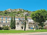a building with an arch in front of a mountain at Holiday Home Le Mas de Marius by Interhome in Cavaillon