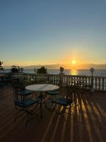 レッジョ・ディ・カラブリアにあるHotel La Lamparaの夕日を背景にテーブルと椅子