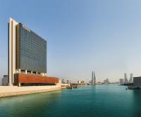 マナーマにあるHilton Garden Inn Bahrain Bayの水域の隣にある大きな建物