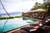 a pool at a resort with chairs and a beach at DoubleTree by Hilton Seychelles Allamanda Resort & Spa in Takamaka