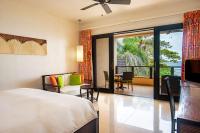 a bedroom with a bed and a patio with a table at DoubleTree by Hilton Seychelles Allamanda Resort & Spa in Takamaka