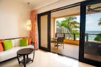 a living room with a couch and a view of the ocean at DoubleTree by Hilton Seychelles Allamanda Resort & Spa in Takamaka