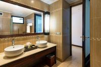 a bathroom with two sinks and a large mirror at DoubleTree by Hilton Seychelles Allamanda Resort & Spa in Takamaka